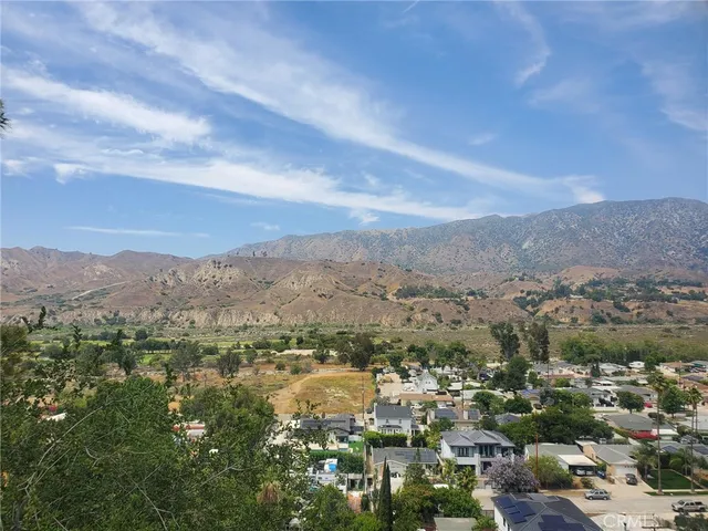 an aerial view of residential houses with outdoor space and trees