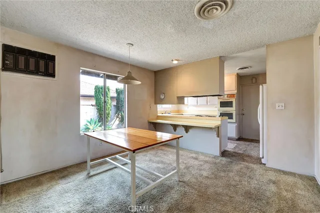 a kitchen with a table chairs refrigerator and microwave