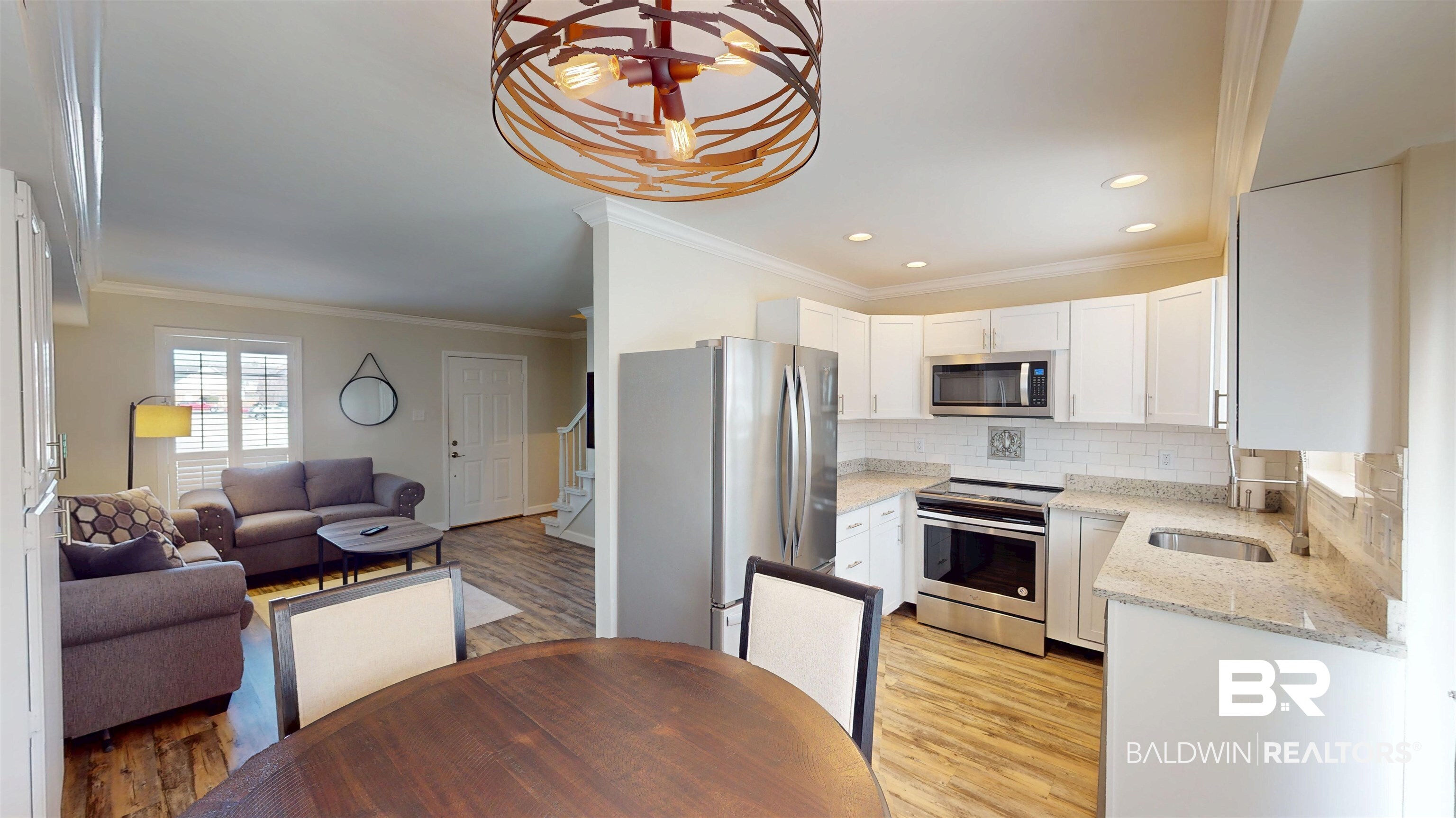 100 Du Rhu Drive, Unit J Mobile, AL 36608 - Photo 10 of 17 Kitchen featuring light stone counters, stainless steel appliances, ornamental molding, white cabinets, and light wood-style floors