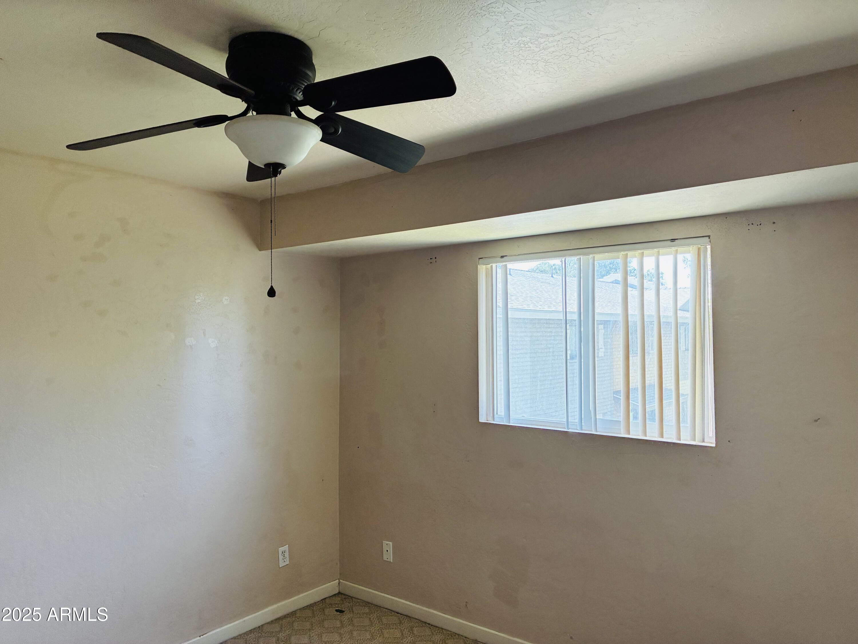 Undisclosed Address Tempe, AZ 85282 - Photo 12 of 23 an empty room with a ceiling fan and a window