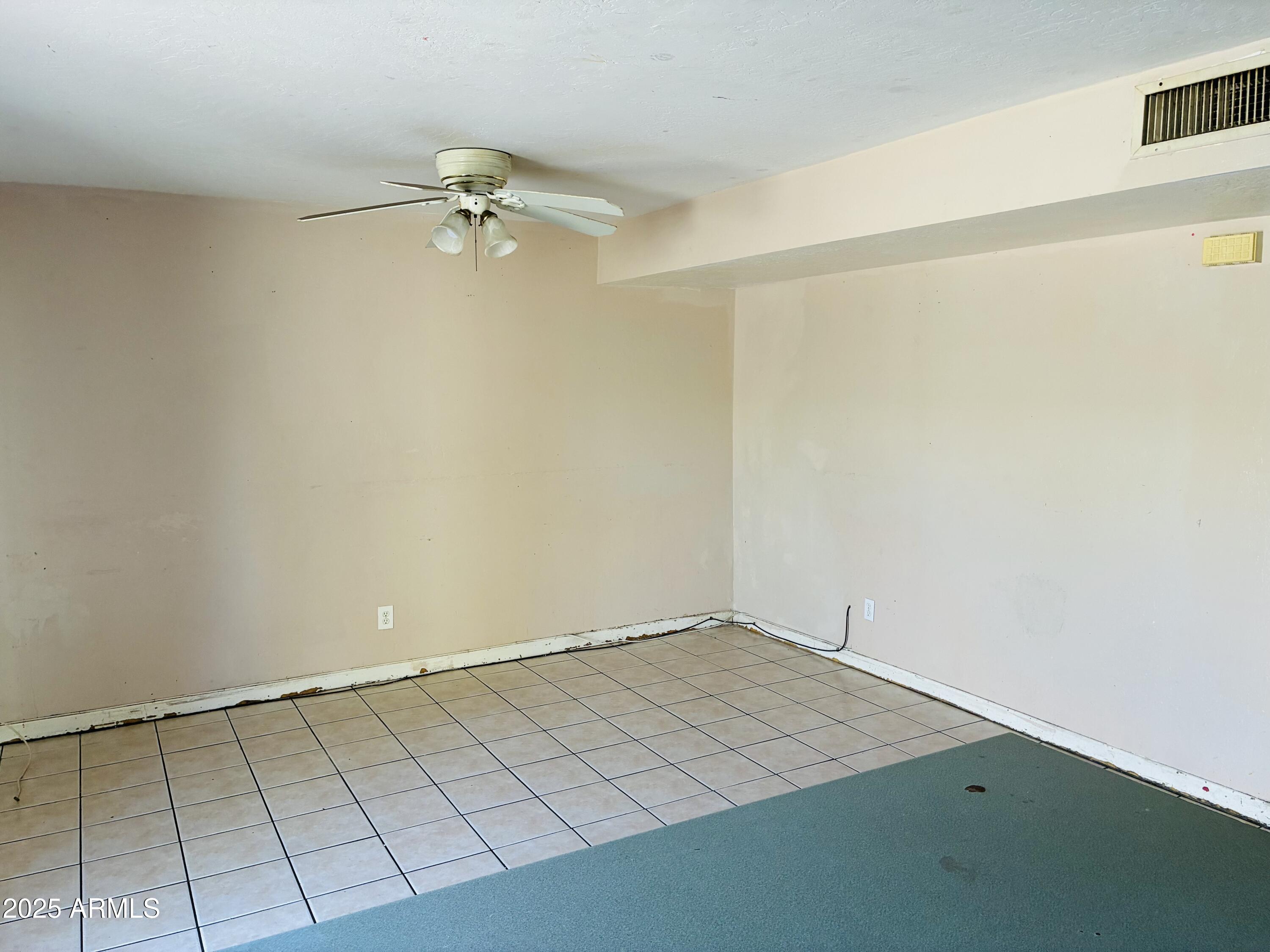 Undisclosed Address Tempe, AZ 85282 - Photo 7 of 23 an empty room with a ceiling fan and wooden floor
