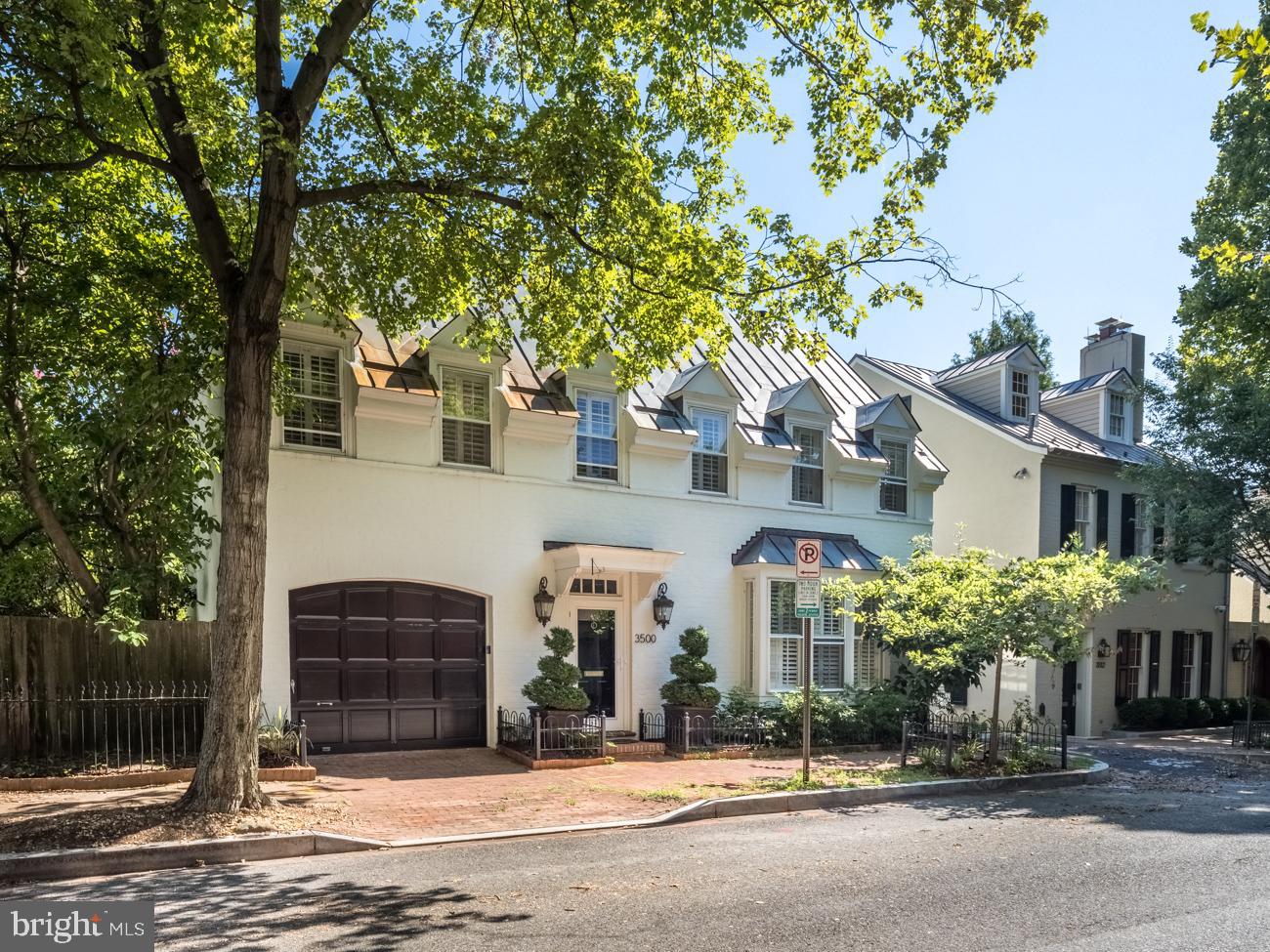 a front view of a house with a tree