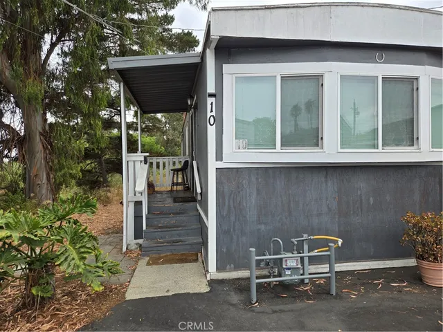 a view of a chair and table in backyard of the house