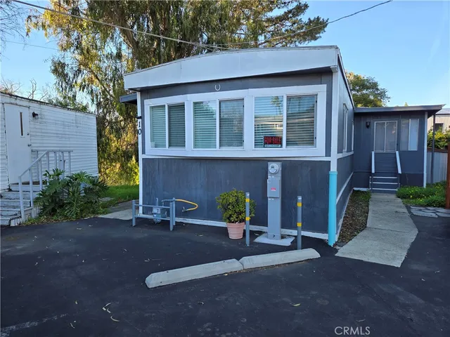 a view of a chair and table in backyard of the house
