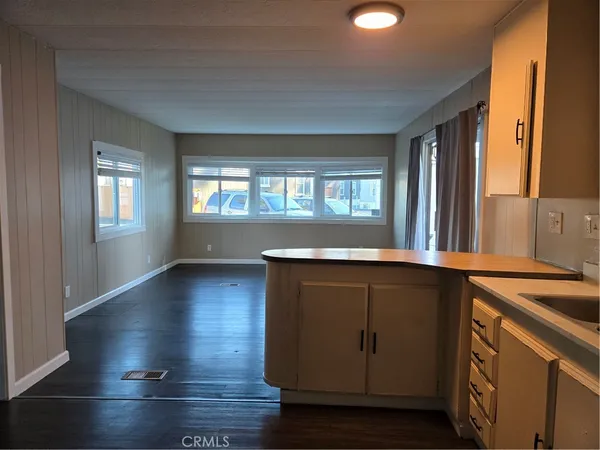 a kitchen with granite countertop white cabinets and wooden floor