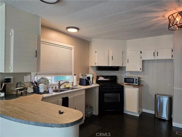 a kitchen with a sink a stove a refrigerator and a window