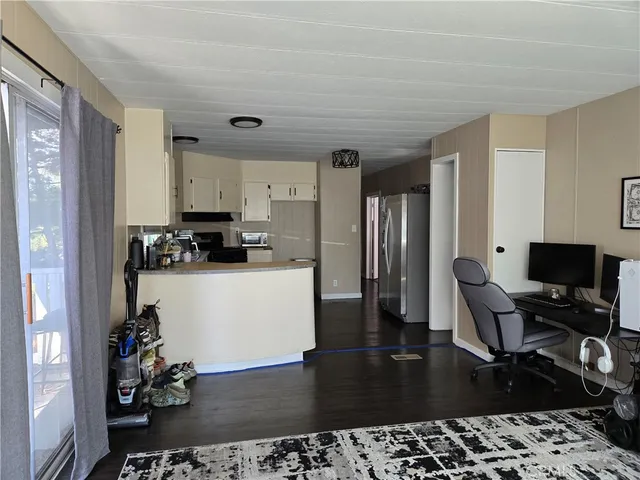 a kitchen with stainless steel appliances kitchen island granite countertop a refrigerator and a sink