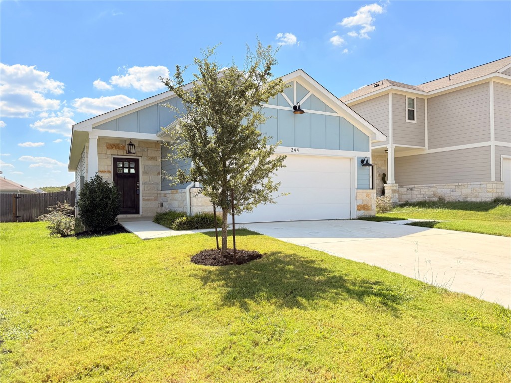 a view of a house with a yard and garage