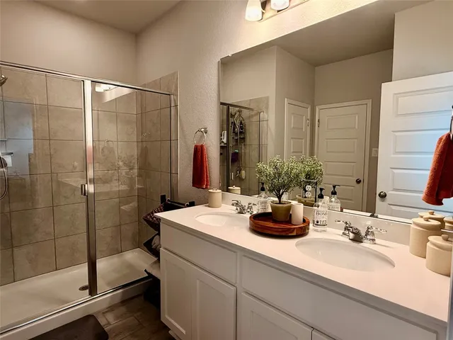 a bathroom with a double vanity sink toilet and shower