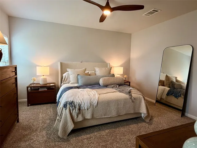 a spacious bedroom with a bed and a mirror