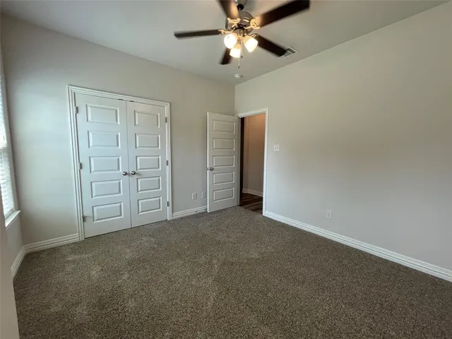 an empty room with closet and windows