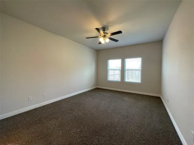an empty room with a window and a ceiling fan