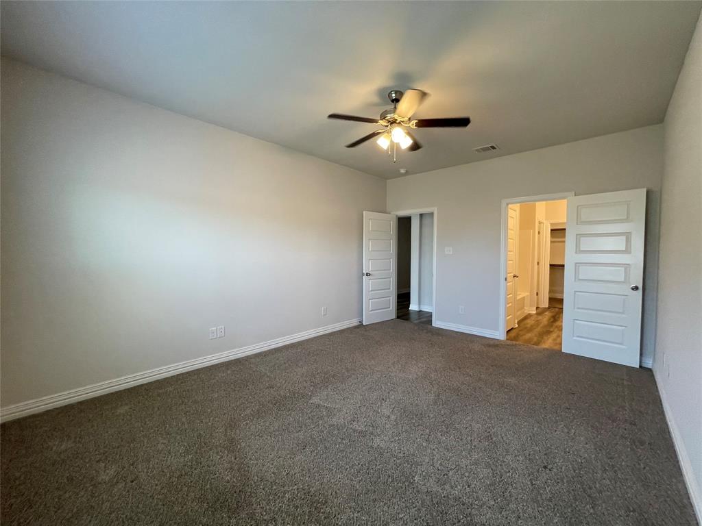 206 South Nolan River Road, Unit 6 Cleburne, TX 76033 - Photo 5 of 16 an empty room with a bathroom and a ceiling fan