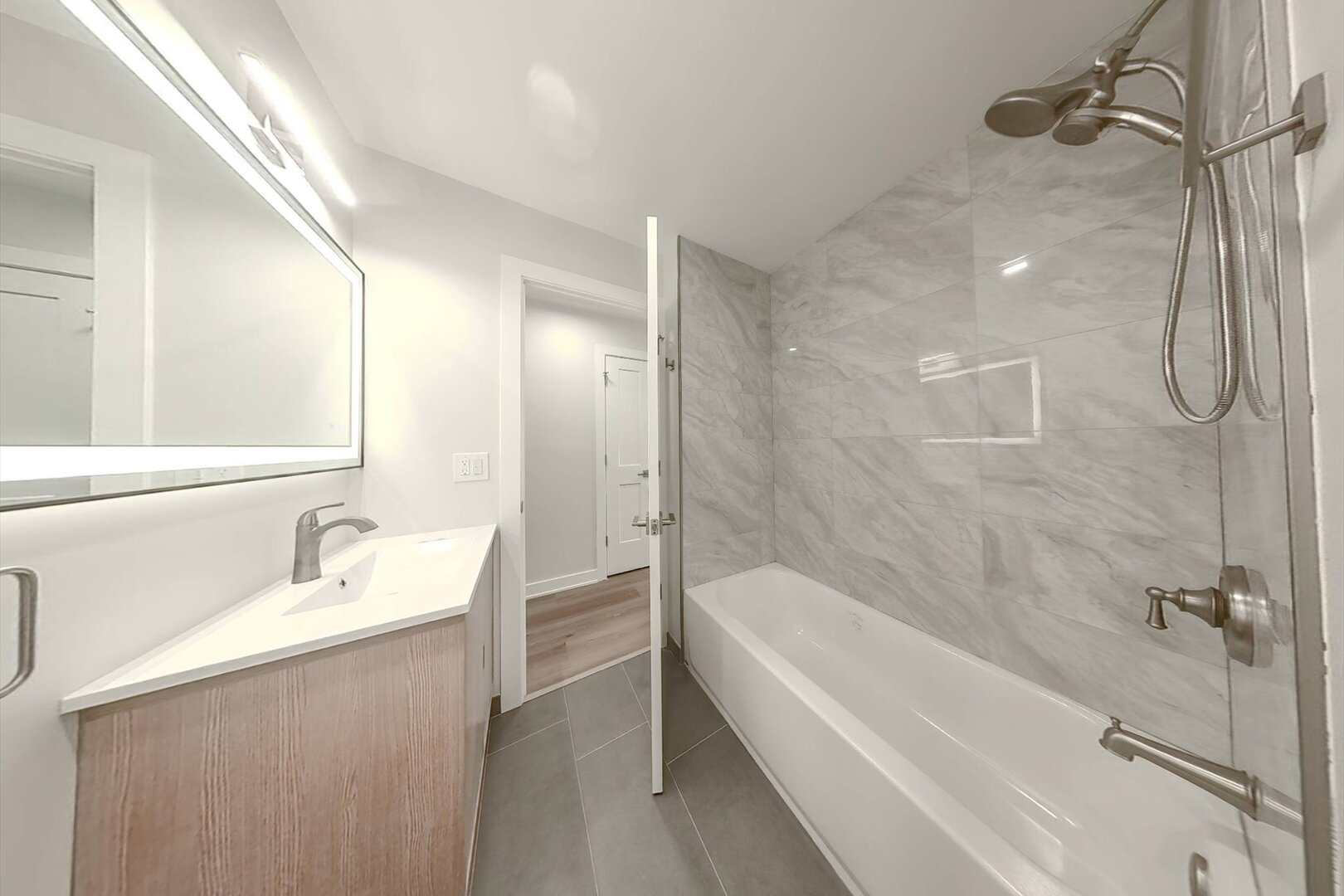 1640 West Sherwin Avenue, Unit 3B Chicago, IL 60626 - Photo 21 of 28 a bathroom with a granite countertop sink a mirror and a bathtub