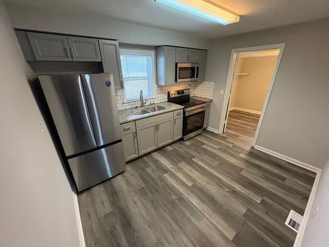 a kitchen with a refrigerator a stove top oven a sink and dishwasher