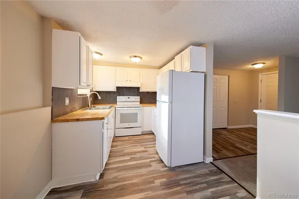 a kitchen with white cabinets and white stainless steel appliances