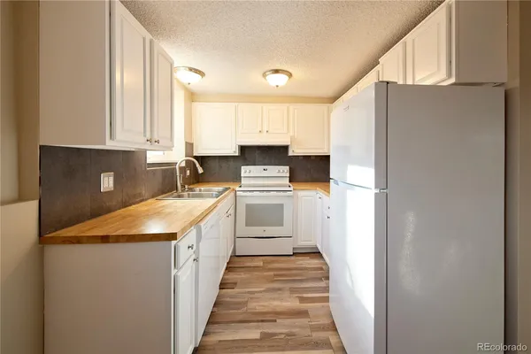 a kitchen with granite countertop a stove sink and cabinets