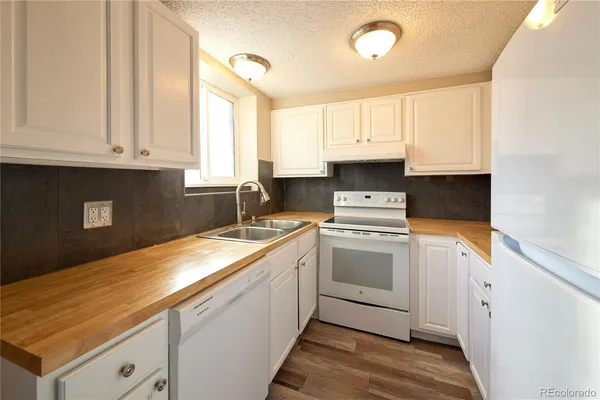 a view of a room with wooden floor and a ceiling fan