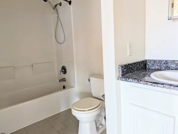 a bathroom with a granite countertop toilet sink and shower
