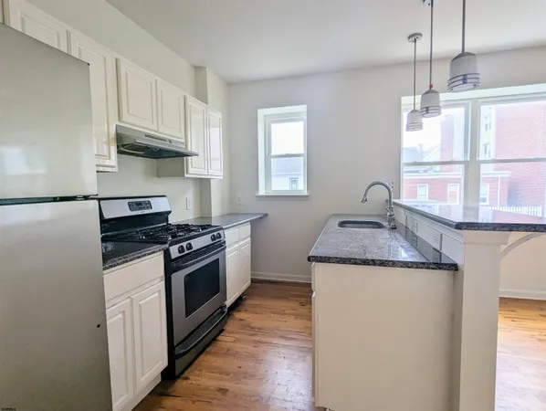 a kitchen with granite countertop a sink and a stove