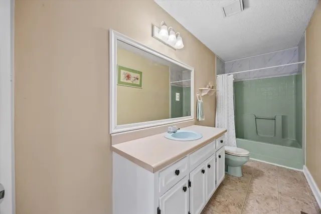 a bathroom with a sink a toilet a mirror and shower