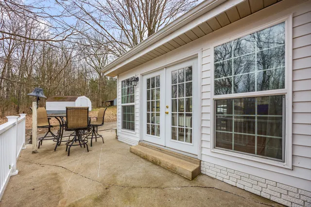 a view of a patio with table and chairs and floor to ceiling window