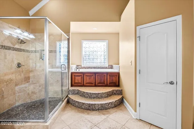 a bathroom with a granite countertop sink a mirror a bathtub and shower