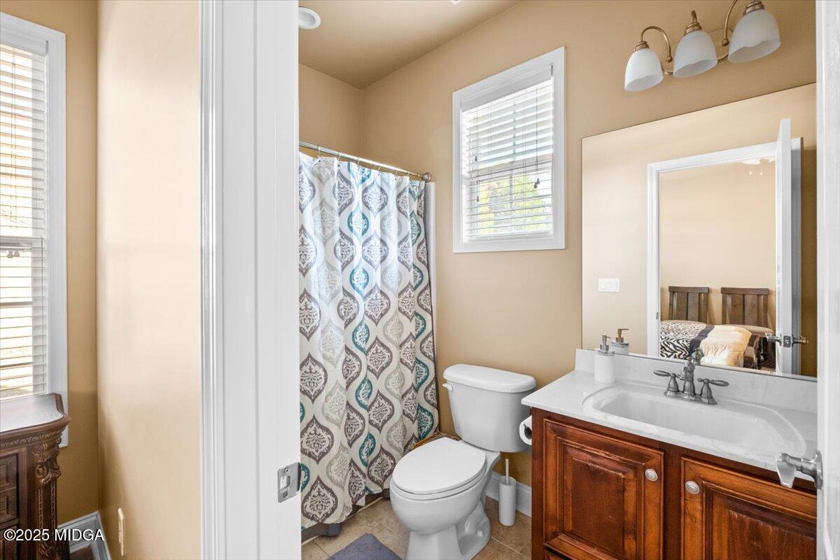 204 Cashmere Court Centerville, GA 31028 - Photo 28 of 51 a bathroom with a granite countertop toilet a sink a mirror a window and a shower