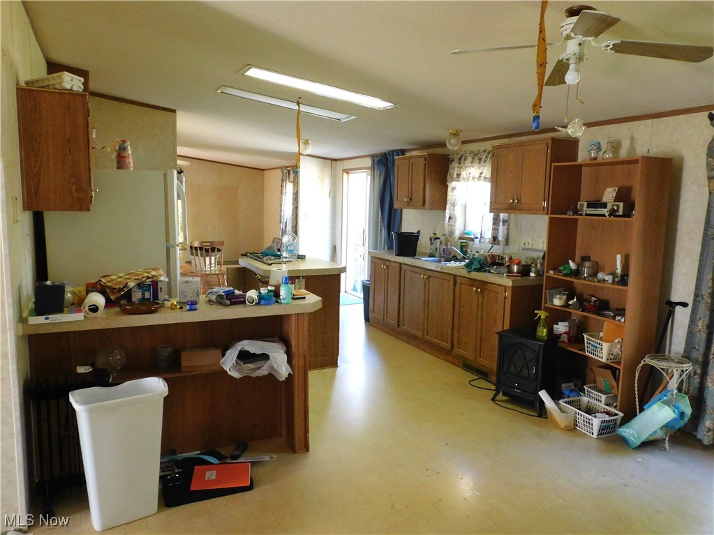 5059 Leon Road Andover, OH 44003 - Photo 6 of 18 Kitchen with freestanding refrigerator, brown cabinets, light countertops, and open shelves
