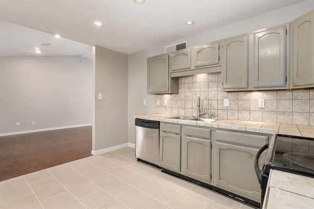 a kitchen with stainless steel appliances granite countertop a sink and a stove