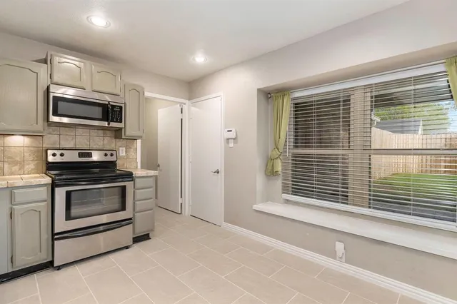 a kitchen with stainless steel appliances a stove sink microwave and cabinets