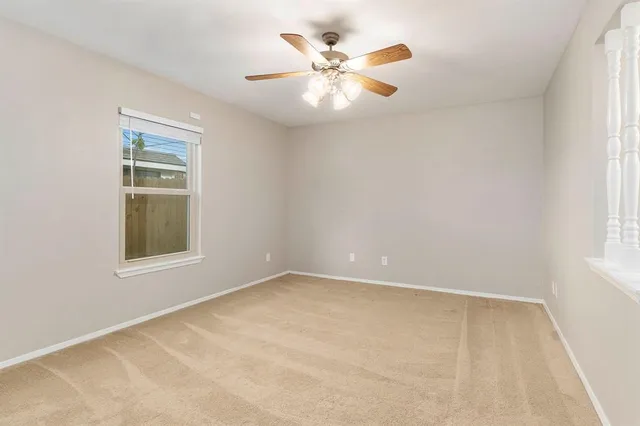 an empty room with a window and a fan
