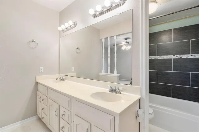 a bathroom with a sink double vanity mirror and a bathtub