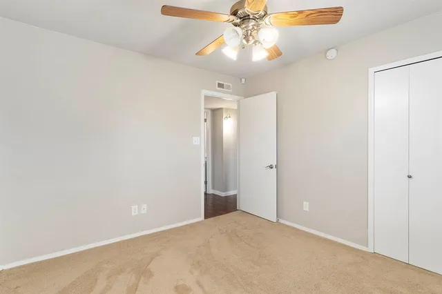 an empty room with a fan and a fan