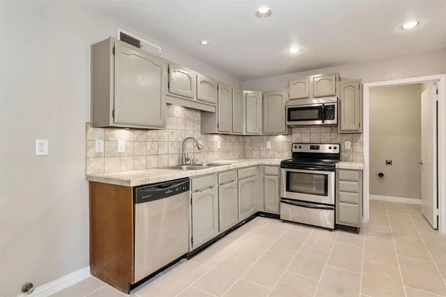 a kitchen with kitchen island a sink stainless steel appliances and cabinets