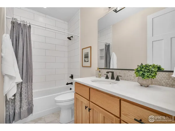 a bathroom with a granite countertop sink a toilet and shower