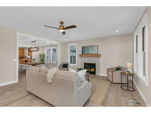 a living room with furniture a rug potted plant and a window