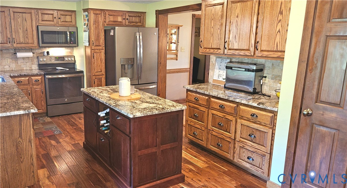 10511 Ashcake Road Ashland, VA 23005 - Photo 21 of 58 a kitchen with stainless steel appliances granite countertop a stove and a refrigerator