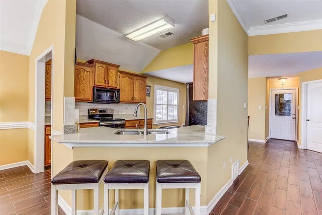 a kitchen with stainless steel appliances granite countertop a refrigerator and a stove top oven