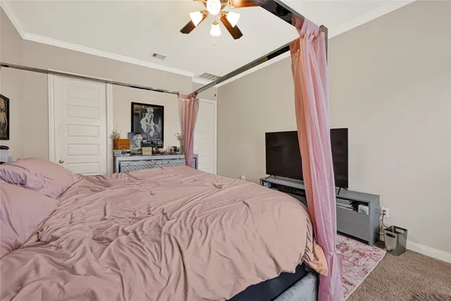 a bedroom with a bed and a flat tv screen on dresser