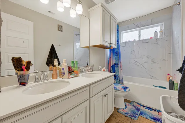 a bathroom with a sink double vanity next to a tub and a large mirror