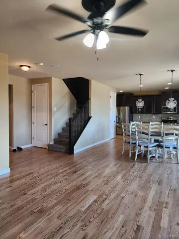 an empty room with wooden floor and way to ceiling window