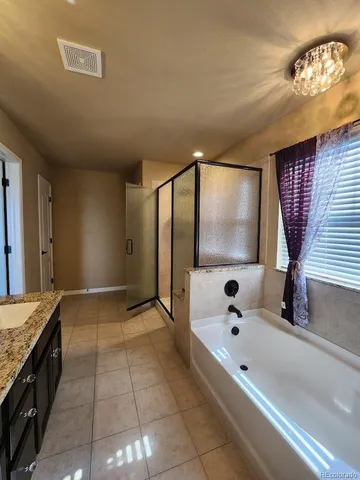 a bathroom with a tub sink and mirror