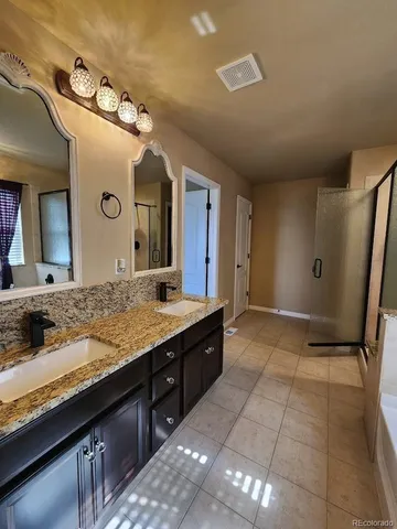 a spacious bathroom with a granite countertop sink and a mirror