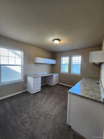 a view of an empty room with closet and a window