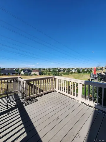 a view of a balcony with wooden floor and fence