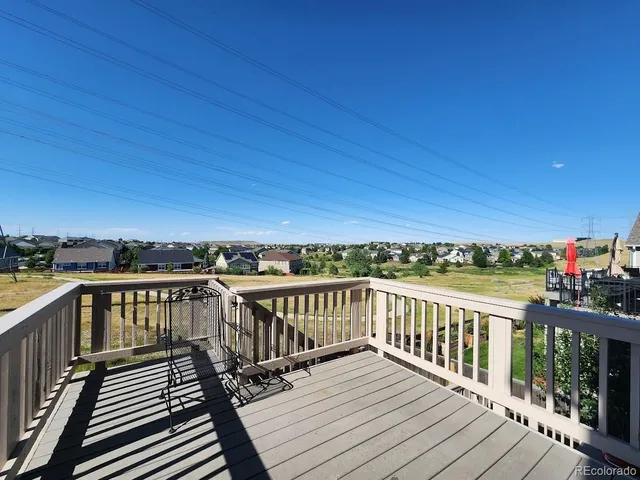 a view of a balcony with wooden floor & fence
