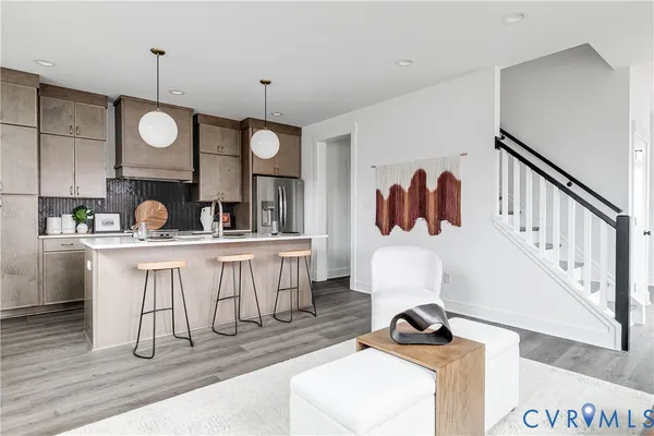 a kitchen with stainless steel appliances a sink a table a refrigerator and wooden cabinets