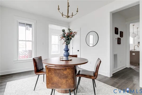 a dining room with chandelier and wooden floor