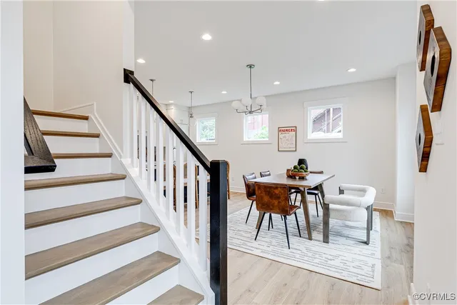 a kitchen with stainless steel appliances granite countertop a sink a stove a refrigerator and island with wooden floor